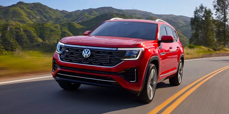 a red 2024 Volkswagen Atlas driving up a highway