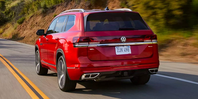 rear view of a red 2024 Volkswagen Atlas driving down a highway