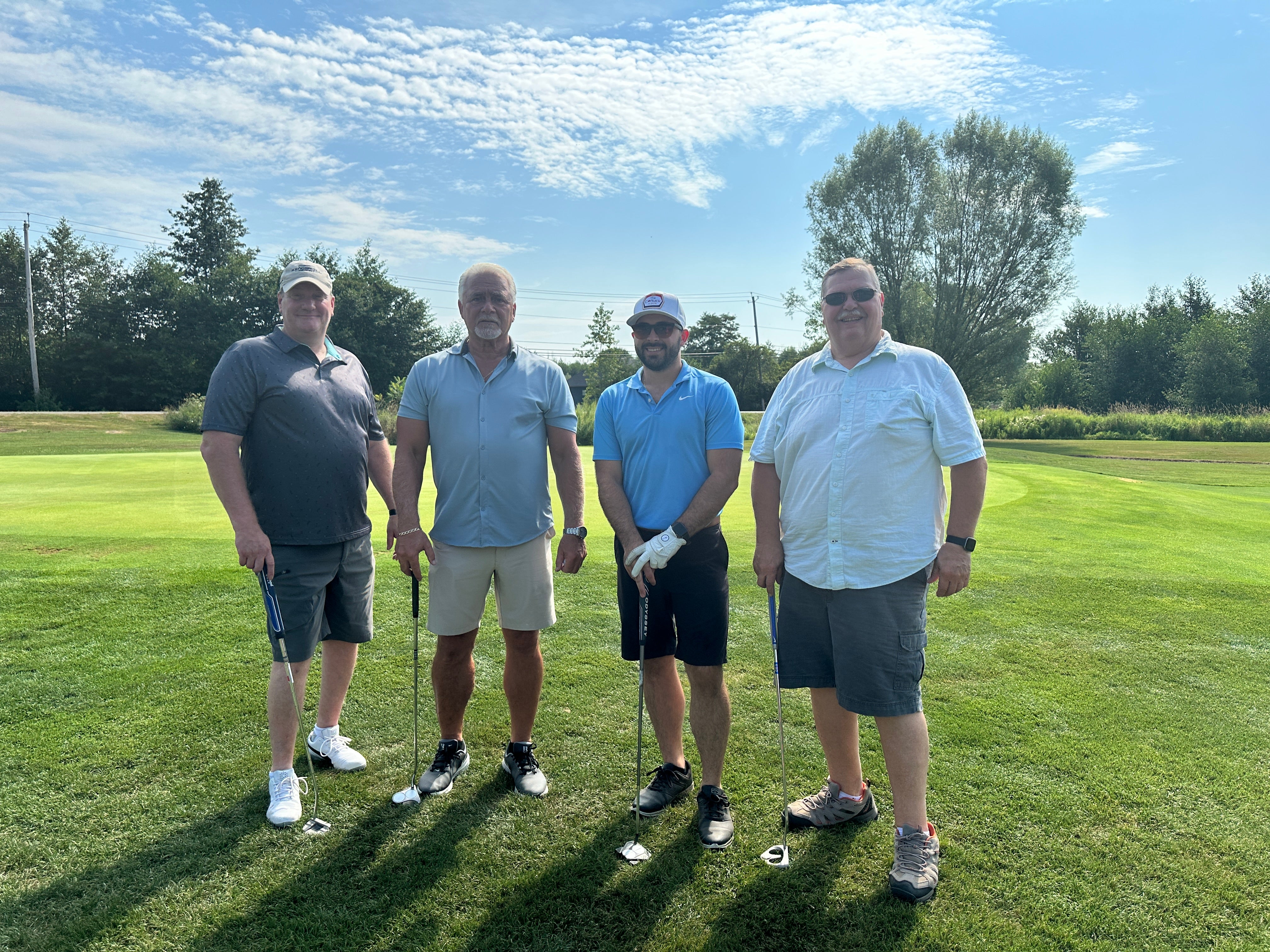 4 adults playing golf