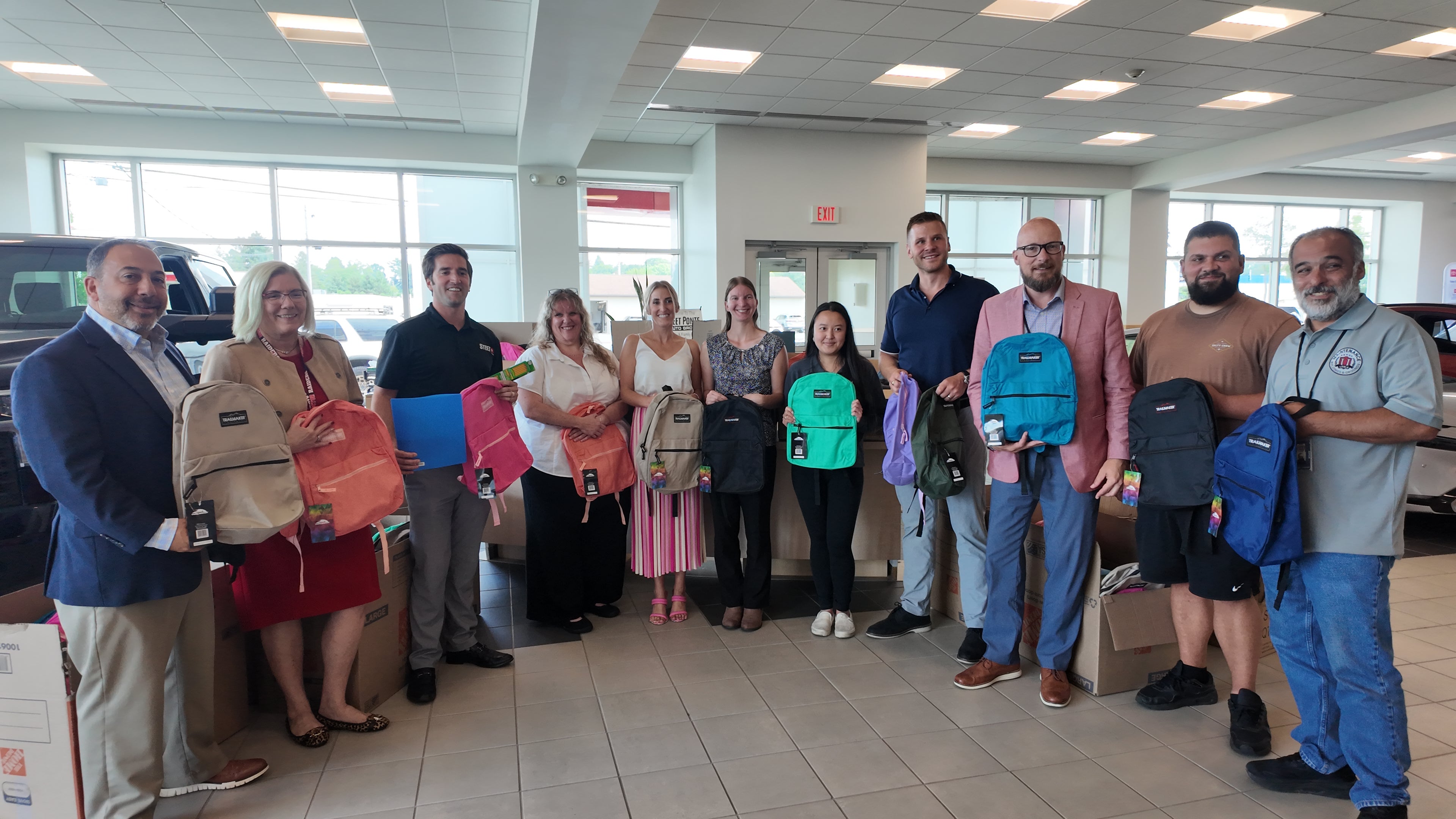 Steet Ponte Auto Group Representatives Presenting Utica City School District Representatives with Backpacks